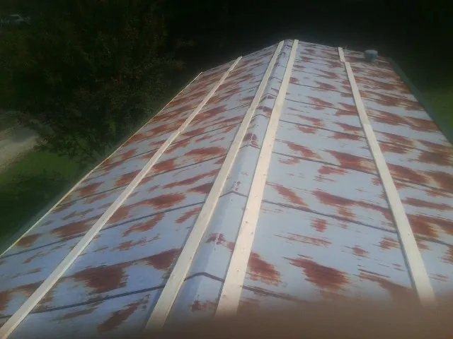 Rusted metal roof panels with new wood purlins before replacement — Storm Damage Roof Repair in Mona by Roofing Brothers