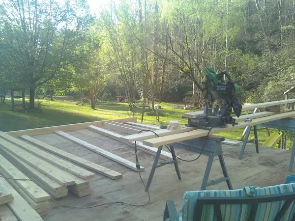 Miter saw and framing lumber on a deck under construction in Mona